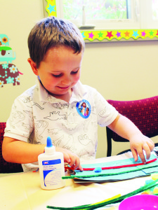 MAKING CRAFTS Youngsters had the chance Sunday to work on Halloween crafts at Village Child Care Centre in Caledon village. Jackson Andron, 4, of Orangeville was hard at work on his creation. Photo by Bill Rea