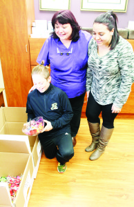 GIVING BACK CANDY A lot of kids received a lot of Halloween candy going door-to-door last Monday night, and in some cases too much. So Bolton Family Dental Centre was buying back the excess, for $1 per pound. Dr. Rosanna Porretta said the collected candy will be going to Canadian Food For Children, while local youngsters reduce their chances of getting cavities. Cameron Besko, 11, of Bolton was making his contribution while Porretta and receptionist Victoria Villari watched. Photo by Bill Rea