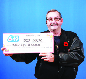 Myles Payne holds his winnings from Lotto 6/49.