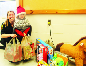 People attending Sunday's breakfast were asked to bring toys, that will be going to Caledon Community Services' Santa Fund. Firefighter Lisa Blundell helped Rosaline Walker, 4, of Brampton make her contribution.