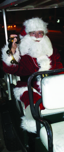It wasn't quite a limo, but Santa Claus didn't seem to mind being driven to the tree lighting in a golf cart. Photos by Bill Rea