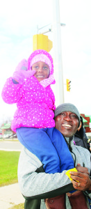 Adedoyin Adenowo of Bolton made sure his daughter Zion, 4, got a good view of Santa as he rode by.