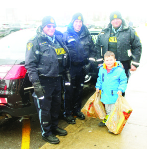 CRAMMING CRUISERS AT CANADIAN TIRE Caledon OPP officers were inviting people to cram police cruisers with toys and other gift items Saturday at the Bolton Canadian Tire store, and they were transporting the goods to the Exchange as part of Caledon Community Services' Santa Fund. Ethan Branco, 4, of Bolton was making a contribution that was accepted by Auxiliary Constable Mike McJannet, Constable Mike Walli and Auxiliary Constable Ciarce Huti. Photo by Bill Rea