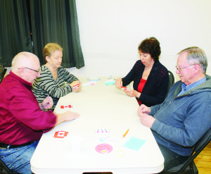 REGULAR EUCHRE NIGHTS ARE HERE Hands were being played and trumps called last Friday night at Terra Cotta Community Hall. Clay Downes, Nancy Downs, Fran Herbert and Dave Evans were playing this hand. The plan is to hold these euchre evenings the first and third Fridays of the month, at a cost of $3 per person. Proceeds will be going toward the operation of the hall. Photo by Bill Rea