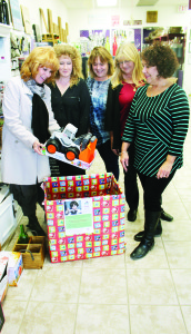 WINE TASTING EVENT SUPPORTS CCS Naked Vine in Bolton hosted a wine tasting event early in December, and participants were asked to bring a toy, gift card or money to go toward the Caledon Community Services Santa Fund. Shirley Pritchard was making her contribution, observed by Kim Villeneuve, Candice Plibersek, Sandy Brown and Vera Robinson. Photo by Bill Rea