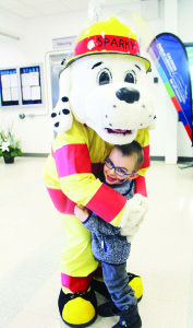 FIREFIGHTERS ON HAND AT WINTERFEST Caledon firefighters were on hand at the recent WinterFest at Mayfield Recreation Complex. They were handing out free scrapers, but the real attraction was Sparky. That's who Evan Quinn, 4, of the Forks of the Credit area, was interested in. Photo by Bill Rea