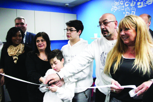 Family and friends of Francesco Molinaro cut the ribbon to officially open Che's Place, a youth centre in Bolton in memory of Molinaro, who was killed Victoria Day weekend in Wasaga Beach. Photo by Jake Courtepatte