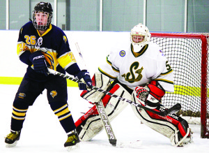 Caledon's Christian Hauck screens Stayner netminder Eric Pitcher during the Hawks' 5-3 win over the Siskins in Caledon East Friday. Photo by Jake Courtepatte