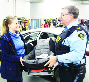 AUXILIARY POLICE HOLD CAR SEAT CLINIC Caledon OPP Auxiliary officers recently held the latest of their child car seat clinics at the Fire Hall in Bolton. Aux. Sergeant Jim Drake was discussing the seat that Bolton resident Courtney Jessop had for her son. The next clinic is scheduled for March. 28 from 6:30 to 9:30 p.m. at the fire hall at 28 Ann St. in Bolton. It will be by-appointment only. Call 905-584-2241 for more information or to book an appointment. Photo by Bill Rea