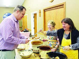 Last Tuesday was the traditional tier for eating pancakes, and they were in ample supply at various location in Caledon. Drew Haines of Brampton was being served his dinner at St. John's Anglican Church on Highway 9 by Margaret French and Susan Schuschu. Photos by Bill Rea