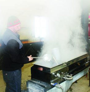 Park Superintendent David Orr can be seen through the steam with sap in the evaporator in the Sugar Shack, Photo by Bill Rea