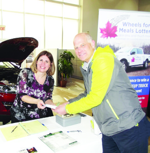 Jan Holland, father of Arizona Coyotes skater (and former Toronto Maple Leaf) Peter Holland, purchased the first lottery ticket from Christine Sevigny, executive director of Caledon Meals on Wheels. Photos by Mark Pavilons